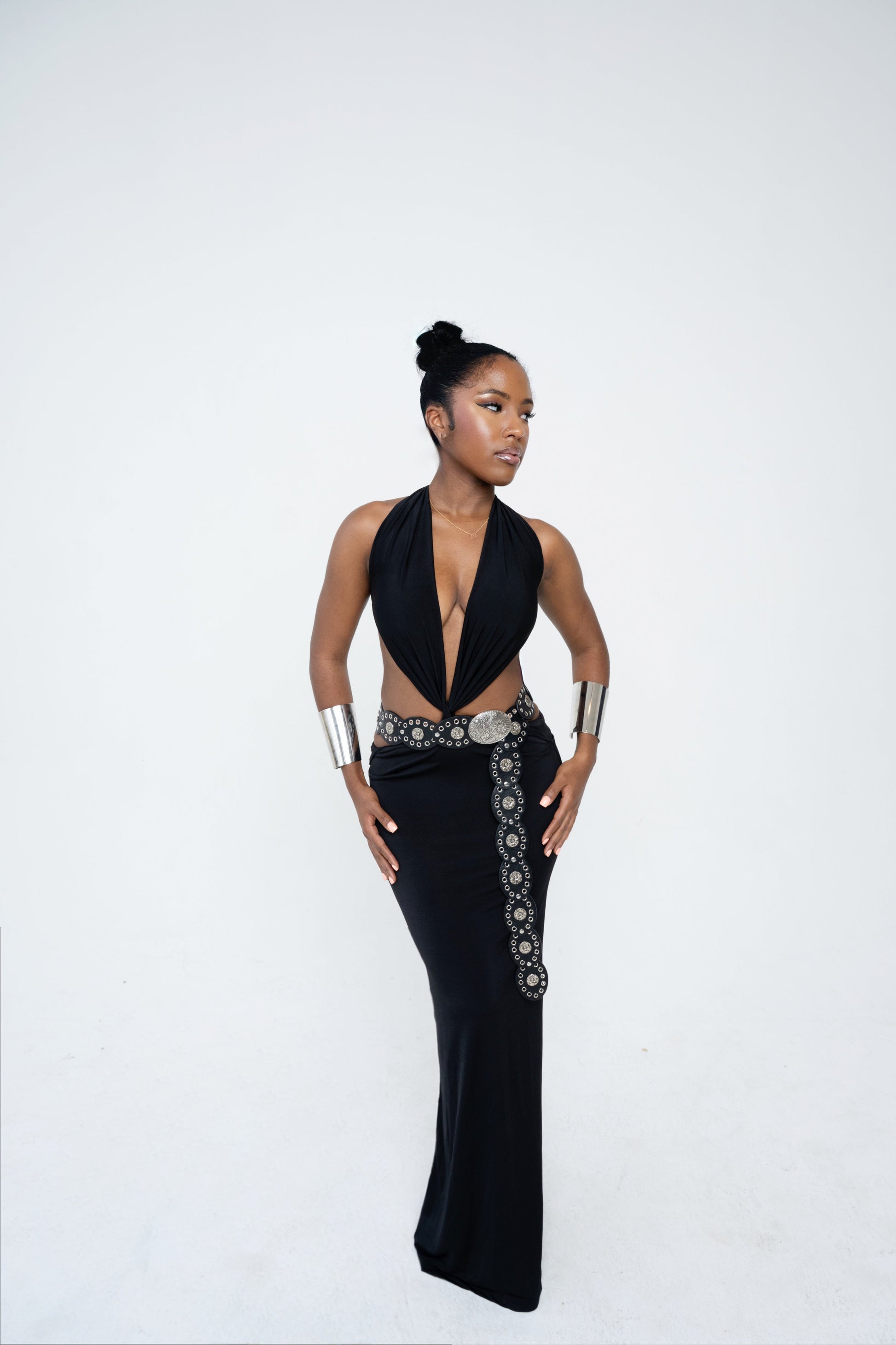 Woman wearing a black dress with silver embellishments on a white background