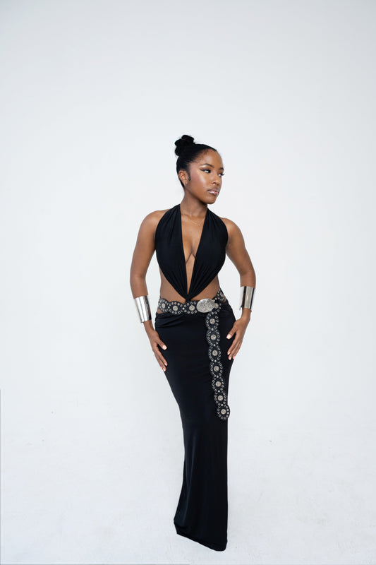 Woman wearing a black dress with silver embellishments on a white background